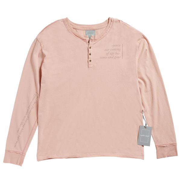 Faded blush long sleeve henley with antique brass buttons, exposed stitching at sides of body, shoulders, and sleeves. Raw edge distressed seams at neck, sleeve cuffs, and hem. Lyrics from the song "peace" printed on left chest, sleeve, and lower back.